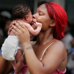 Hurricane refugee Quintelle Williams holds up her 9 day old baby Ikea after making her way through a line of thousands of refugees waiting to leave the city by bus Thursday morning at the Superdome.