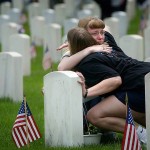 Stephanie Ridgeway holds Alicia Ross next to her great grandfathers grave after the memorial day ceramony in the National cemetary at the Rock Island Arsonal.